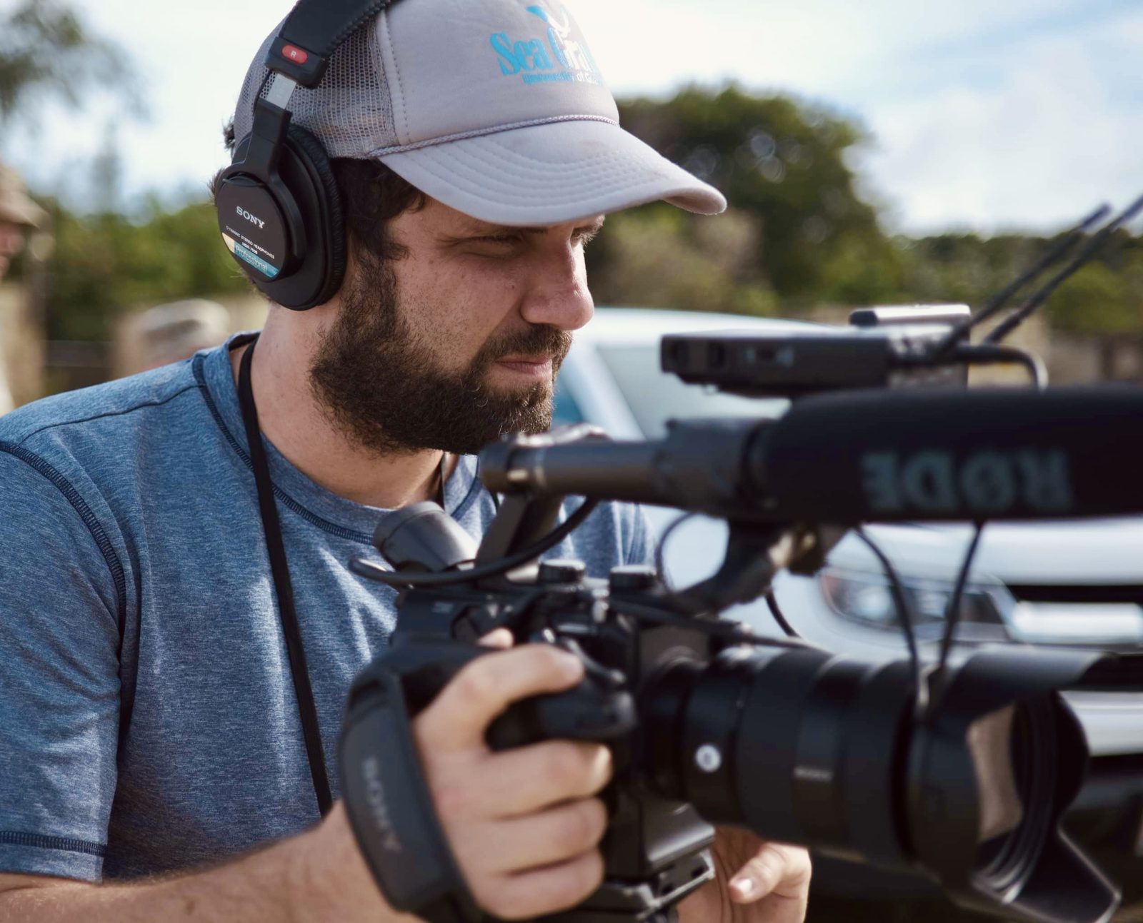 Tony Azios filming with a camera and shotgun microphone